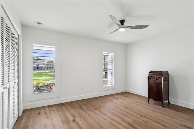 unfurnished bedroom featuring light wood-style floors, baseboards, and ceiling fan