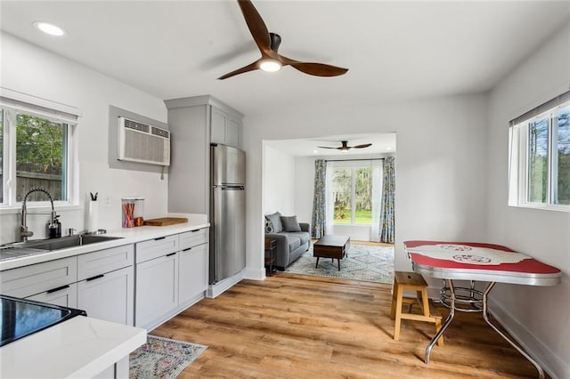 kitchen with freestanding refrigerator, a sink, healthy amount of natural light, a ceiling fan, and recessed lighting