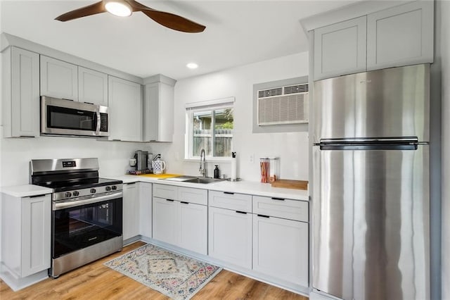 kitchen with stainless steel appliances, a sink, light countertops, a ceiling fan, and recessed lighting