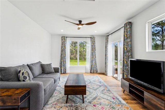 living area with plenty of natural light, wood finished floors, a ceiling fan, and recessed lighting