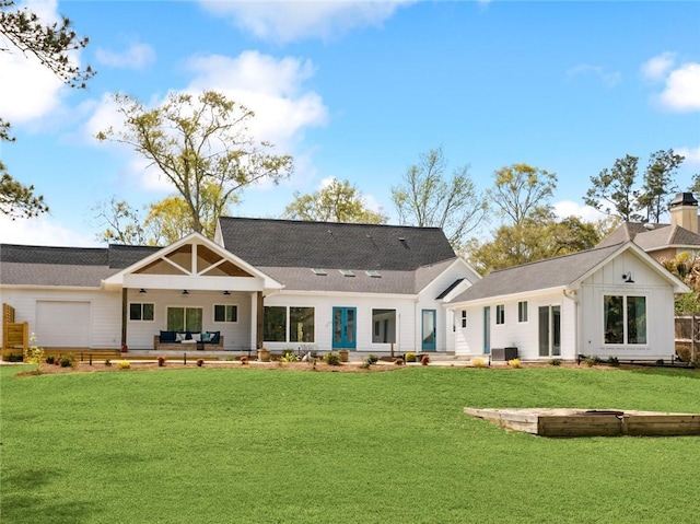 rear view of house with a yard, outdoor lounge area, board and batten siding, a patio area, and central AC