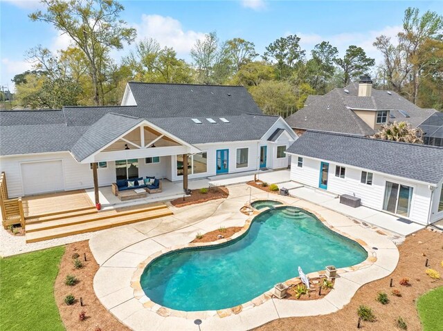 view of swimming pool featuring a wooden deck, an outdoor living space, a patio, and a pool with connected hot tub