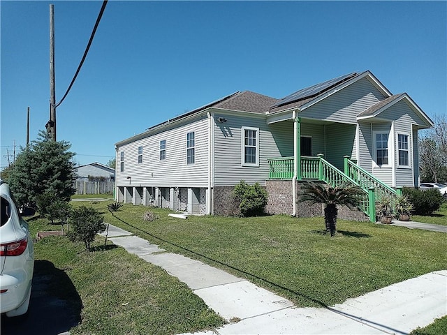 4800 Eastview Dr, New Orleans, LA 70126 - view of front of property with solar panels, a front yard, a porch, and roof with shingles