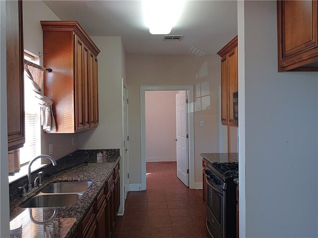 4800 Eastview Dr, New Orleans, LA 70126 - kitchen with stainless steel gas range oven, a sink, and dark stone counters