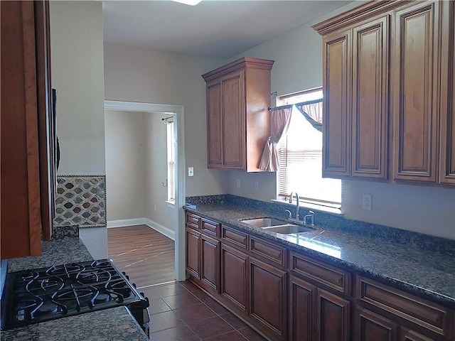 4800 Eastview Dr, New Orleans, LA 70126 - kitchen with baseboards, dark tile patterned floors, a sink, and black gas range