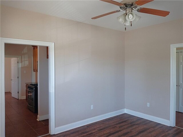 4800 Eastview Dr, New Orleans, LA 70126 - empty room featuring dark wood finished floors, baseboards, a wood stove, and a ceiling fan