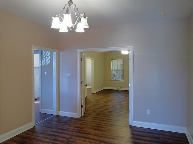 4800 Eastview Dr, New Orleans, LA 70126 - unfurnished room featuring dark wood-type flooring, baseboards, and a notable chandelier