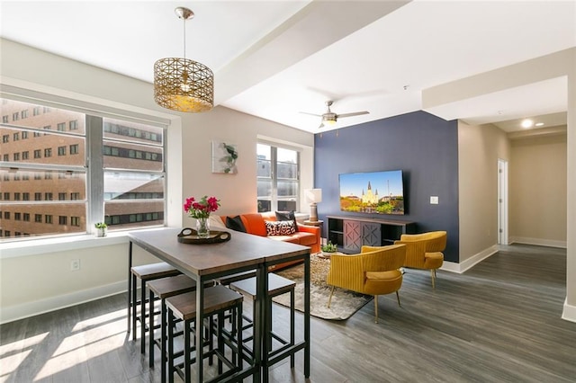 dining area with a ceiling fan, baseboards, and wood finished floors