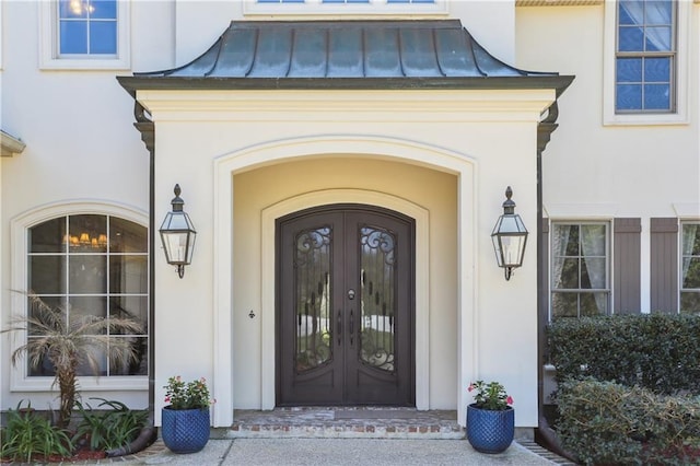 192 Forest Oaks Dr, New Orleans, LA 70131 - view of exterior entry with stucco siding, french doors, metal roof, and a standing seam roof