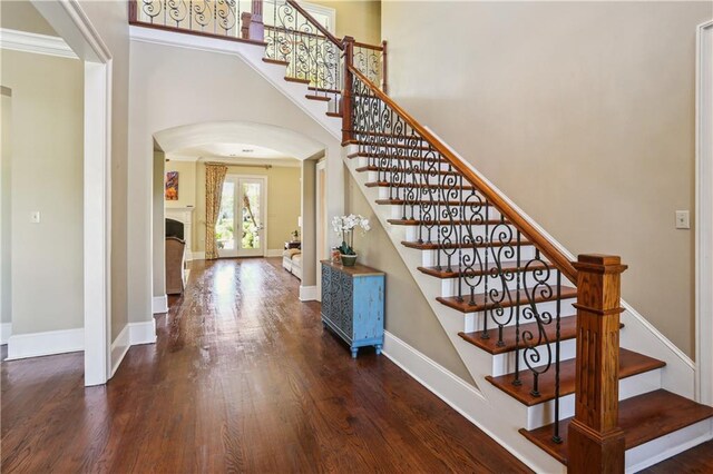 192 Forest Oaks Dr, New Orleans, LA 70131 - entrance foyer featuring baseboards, stairs, a towering ceiling, wood finished floors, and arched walkways