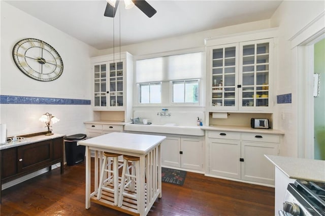 1930 N Rampart St, New Orleans, LA 70116 - kitchen with stainless steel range oven, glass insert cabinets, light countertops, white cabinets, and a ceiling fan
