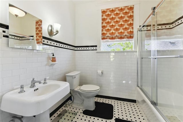 1930 N Rampart St, New Orleans, LA 70116 - full bath featuring tile walls, toilet, a sink, wainscoting, and enclosed tub / shower combo