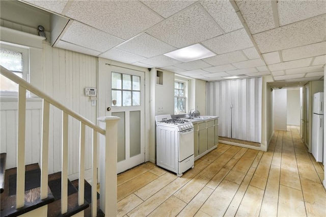 1930 N Rampart St, New Orleans, LA 70116 - kitchen with white appliances, light wood finished floors, light countertops, and a drop ceiling
