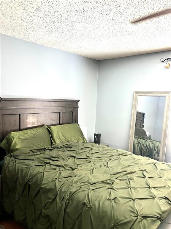 bedroom with a textured ceiling and a ceiling fan