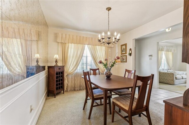 dining room featuring a notable chandelier, light colored carpet, and plenty of natural light