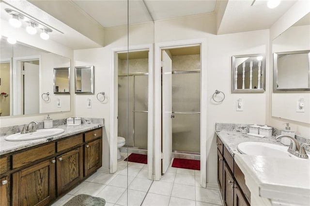 full bathroom with a stall shower, two vanities, and a sink