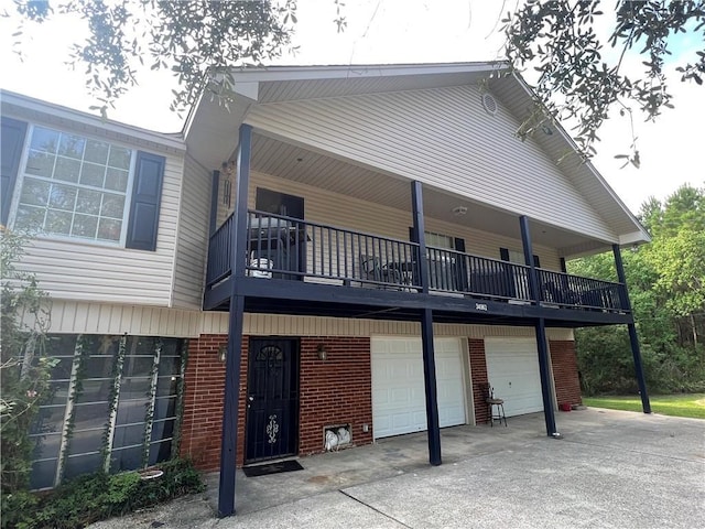 34062 Laurent Rd, Slidell, LA 70460 - rear view of house featuring brick siding, a balcony, a garage, and concrete driveway