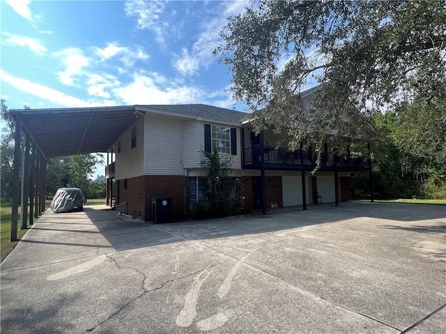 34062 Laurent Rd, Slidell, LA 70460 - view of property exterior with driveway, brick siding, an attached garage, and a carport