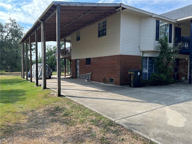 34062 Laurent Rd, Slidell, LA 70460 - view of side of home with an attached carport, driveway, brick siding, and a lawn