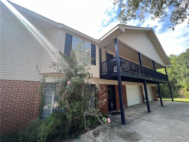 34062 Laurent Rd, Slidell, LA 70460 - view of property exterior featuring brick siding, an attached garage, driveway, and a balcony