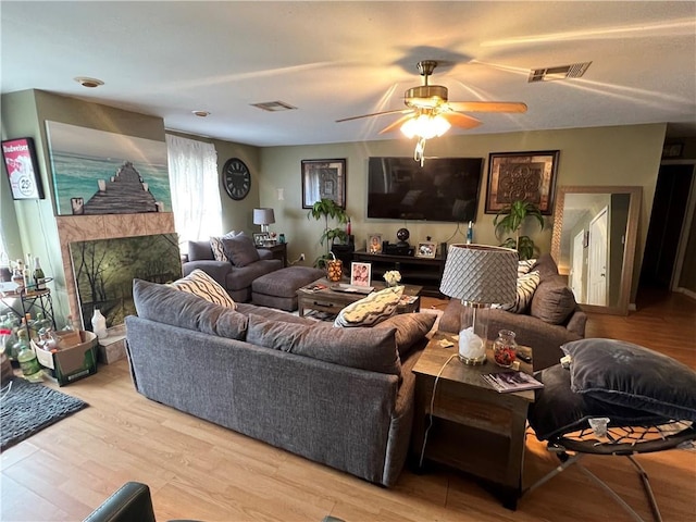 34062 Laurent Rd, Slidell, LA 70460 - living room featuring a ceiling fan, light wood-type flooring, and a tile fireplace
