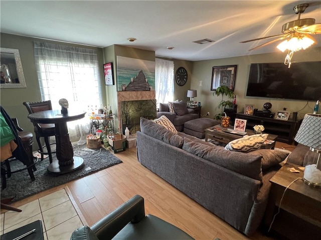 34062 Laurent Rd, Slidell, LA 70460 - living area featuring a ceiling fan, plenty of natural light, a fireplace with raised hearth, and wood finished floors