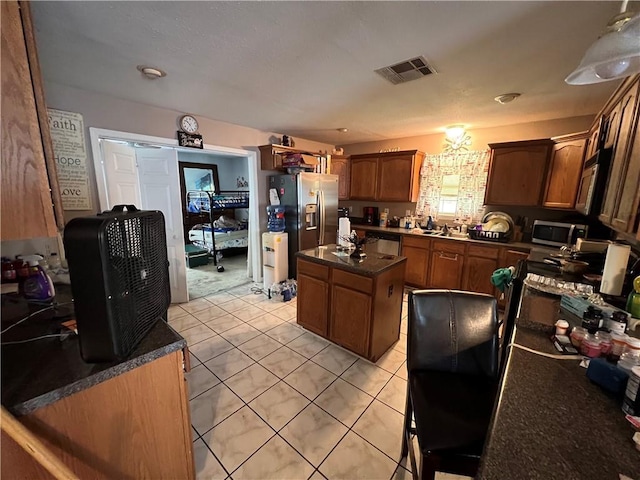 34062 Laurent Rd, Slidell, LA 70460 - kitchen featuring dark countertops, stainless steel appliances, a kitchen island, and light tile patterned floors