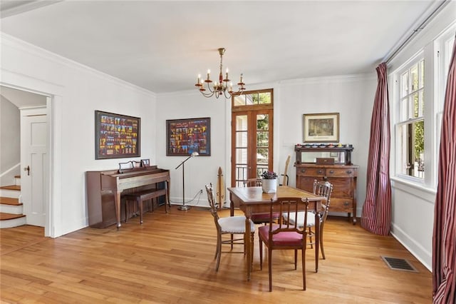 303 Audubon St, New Orleans, LA 70118 - dining space featuring light wood finished floors, a chandelier, stairs, ornamental molding, and baseboards