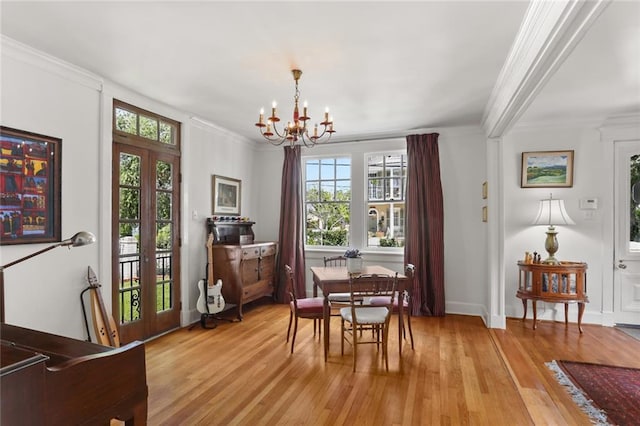 303 Audubon St, New Orleans, LA 70118 - dining room featuring french doors, a chandelier, light wood-type flooring, and crown molding