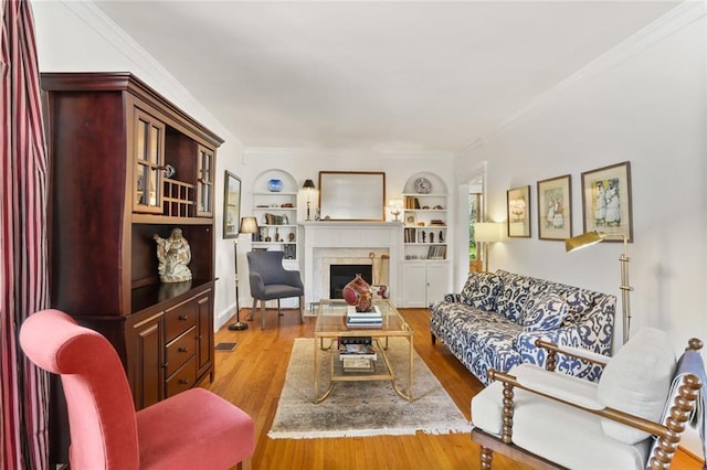 303 Audubon St, New Orleans, LA 70118 - living area with a fireplace, wood finished floors, crown molding, and built in shelves