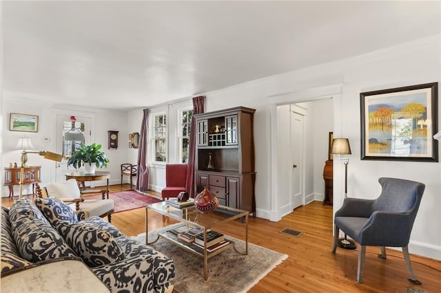 303 Audubon St, New Orleans, LA 70118 - living room with baseboards, light wood-type flooring, and ornamental molding