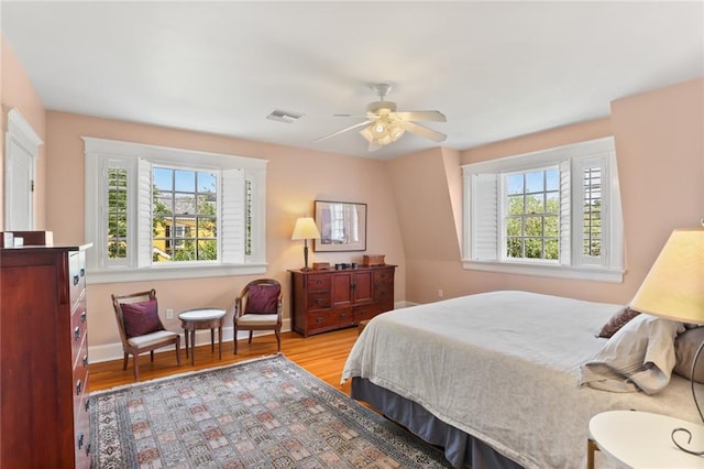 303 Audubon St, New Orleans, LA 70118 - bedroom featuring multiple windows, wood finished floors, baseboards, and a ceiling fan