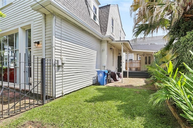 303 Audubon St, New Orleans, LA 70118 - view of home's exterior with a lawn, roof with shingles, and a patio