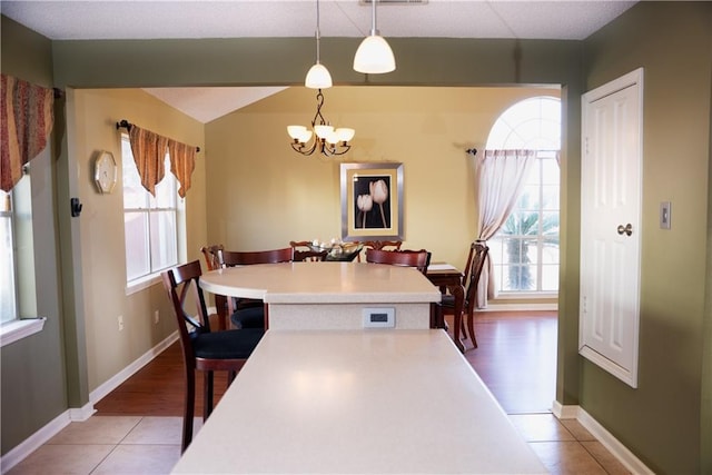 115 Silverwood Dr, Slidell, LA 70461 - dining area with light tile patterned flooring, baseboards, and an inviting chandelier