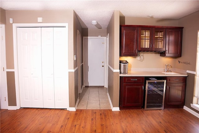 115 Silverwood Dr, Slidell, LA 70461 - kitchen with light wood-type flooring, light countertops, wine cooler, and a sink