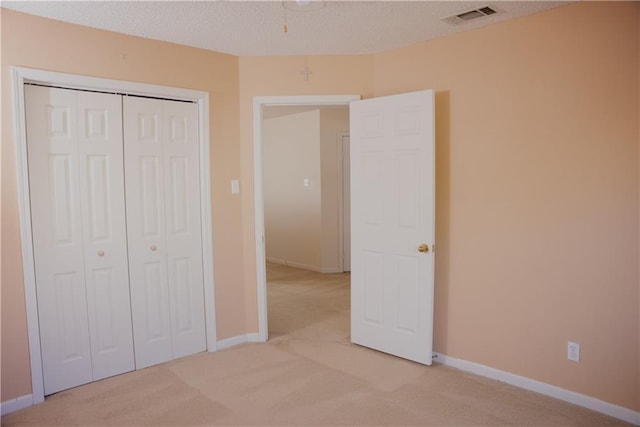 115 Silverwood Dr, Slidell, LA 70461 - unfurnished bedroom with a closet, a textured ceiling, visible vents, baseboards, and light carpet