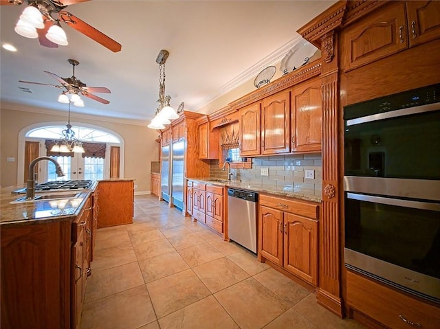 kitchen with a sink, french doors, a ceiling fan, appliances with stainless steel finishes, and decorative backsplash