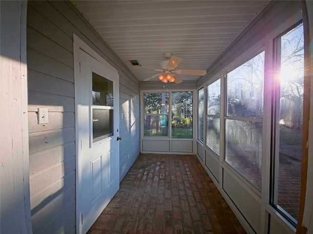 unfurnished sunroom featuring ceiling fan and visible vents