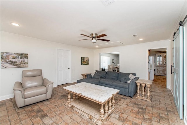 living area with a ceiling fan, a barn door, baseboards, visible vents, and recessed lighting