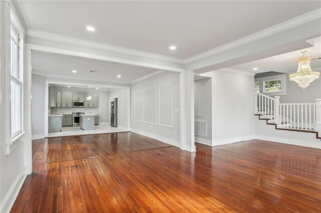 444244 S Johnson St, New Orleans, LA 70125 - unfurnished living room with crown molding, stairway, an inviting chandelier, dark wood finished floors, and visible vents