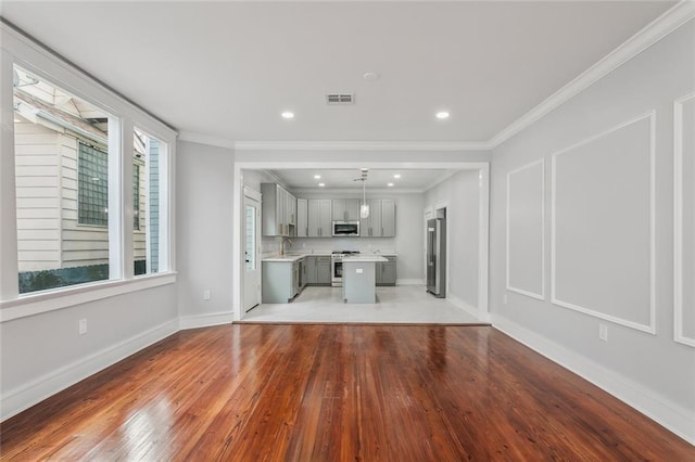 444244 S Johnson St, New Orleans, LA 70125 - unfurnished living room featuring a sink, light wood-style flooring, baseboards, visible vents, and ornamental molding