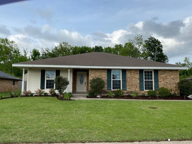 ranch-style house featuring brick siding, a shingled roof, and a front lawn