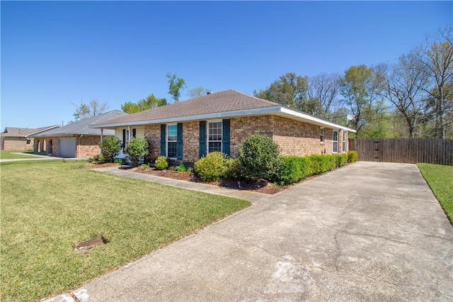 single story home with a front lawn, fence, brick siding, and a garage