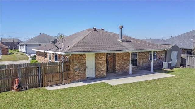 rear view of house featuring fence, central AC, brick siding, a lawn, and a patio area