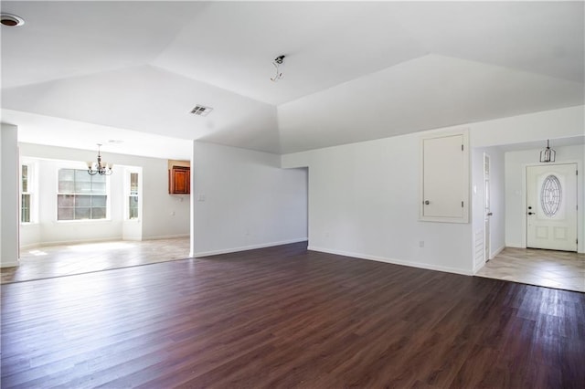 unfurnished living room featuring lofted ceiling, dark wood-type flooring, baseboards, a chandelier, and visible vents