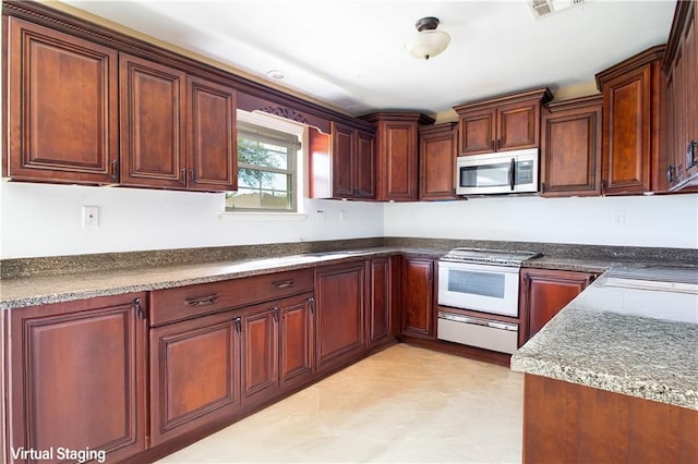 kitchen with stainless steel microwave, white range, and visible vents