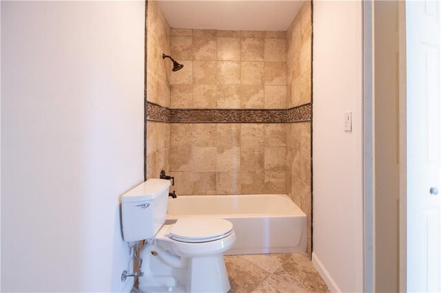 bathroom featuring baseboards, toilet, tile patterned flooring, and shower / washtub combination