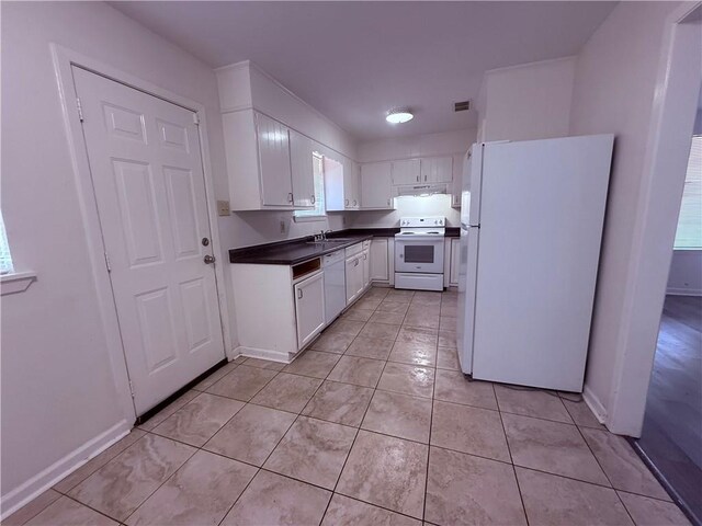 774-776 Holt Dr, Baton Rouge, LA 70815 - kitchen featuring under cabinet range hood, light tile patterned floors, white appliances, dark countertops, and white cabinets