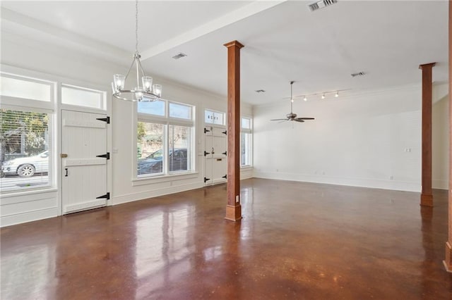 foyer featuring decorative columns, healthy amount of natural light, finished concrete flooring, and a chandelier