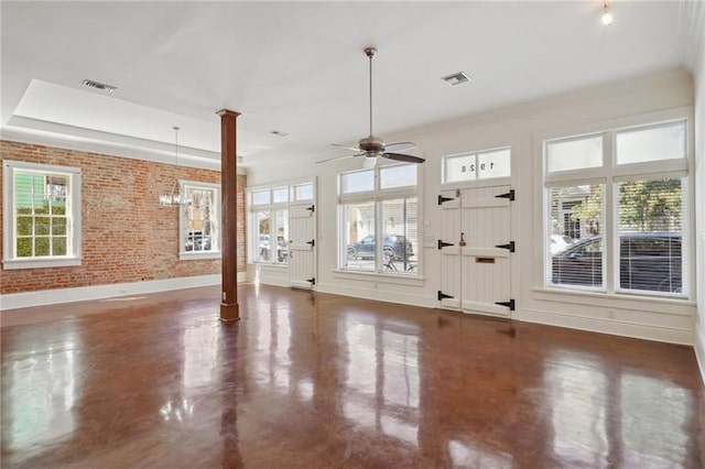 unfurnished living room with plenty of natural light, decorative columns, ceiling fan, finished concrete flooring, and brick wall